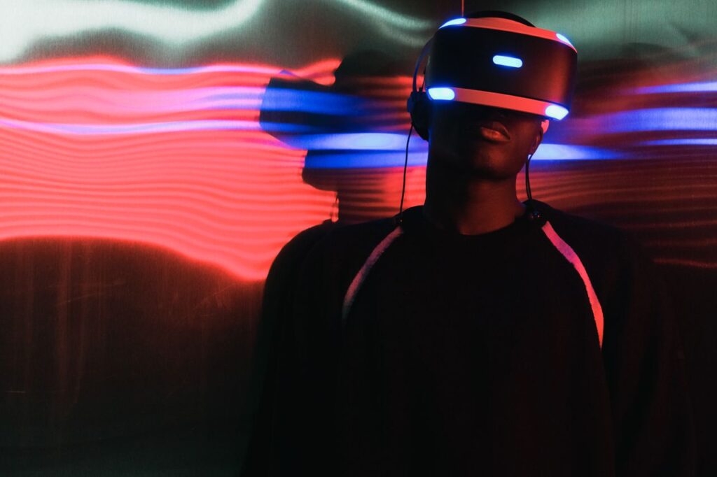 A person wearing virtual reality headset surrounded by colorful neon lights, enjoying a digital world.